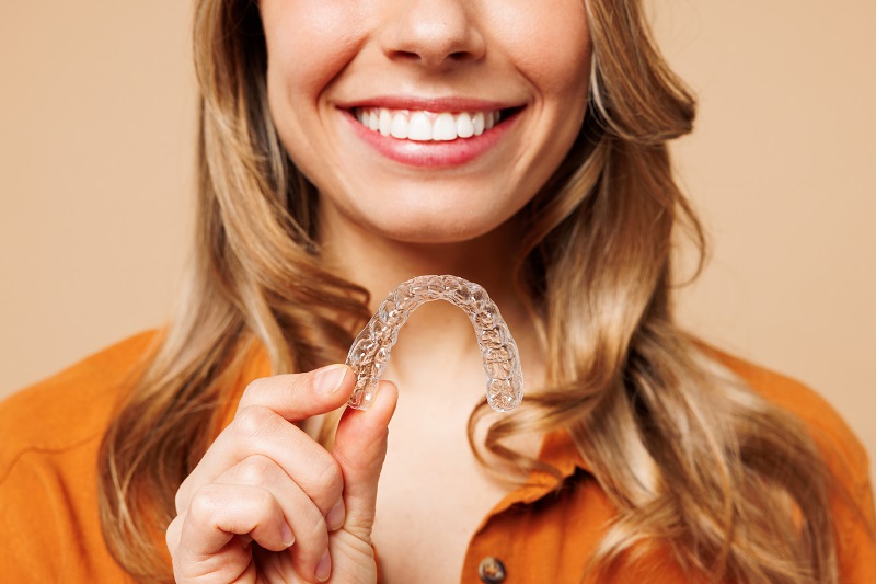 woman holding a clear aligner