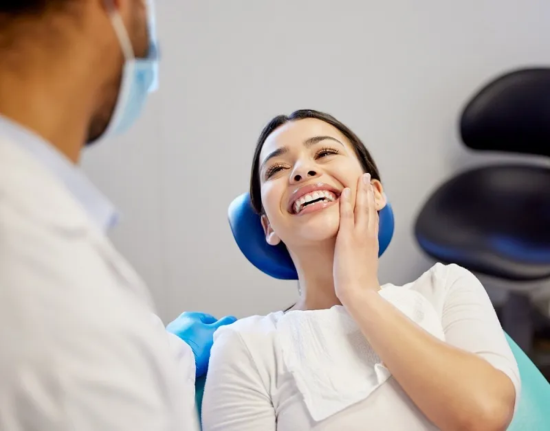 smiling patient holding jaw