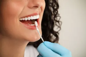 Woman getting her teeth checked by prosthodontist
